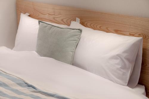 a bed with white pillows and a wooden headboard at Mutal Stay in Seoul