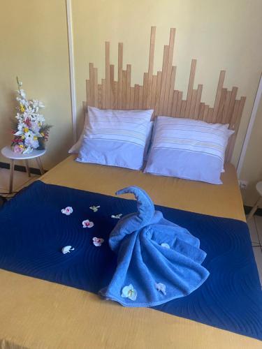 a bedroom with a bed with a blue towel on it at L'Endémik Kréol in Saint-André