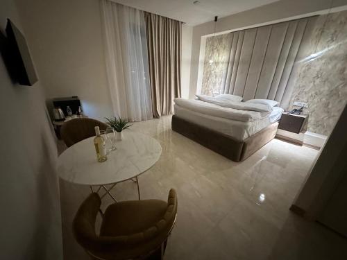 a bedroom with a bed and a table and chairs at Lux Plaza in Pʼarakʼar