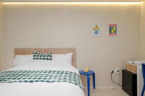 a bedroom with a bed with a green and white blanket at Mutal Stay in Seoul