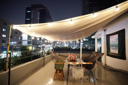 a rooftop patio with a table and chairs on a building at Mutal Stay in Seoul