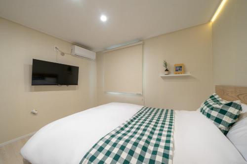 a bedroom with a bed with a checkered blanket at Mutal Stay in Seoul