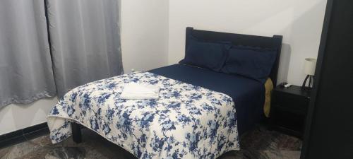 a bedroom with a bed with a blue and white blanket at Ótimo Apto Centro SP Tudo a Pé in Sao Paulo