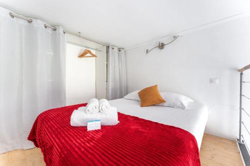 - une chambre avec un lit et des serviettes sur une couverture rouge dans l'établissement Silk - Studio en plein coeur de Lyon, à Lyon