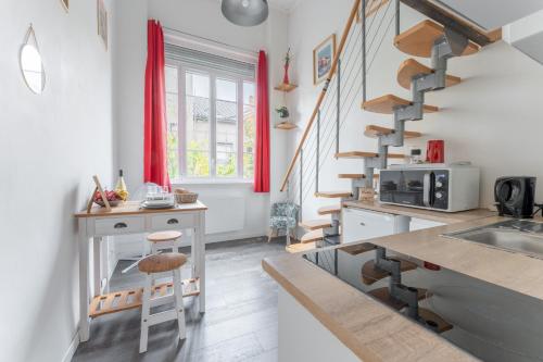 une cuisine avec un escalier en colimaçon dans une maison dans l'établissement Silk - Studio en plein coeur de Lyon, à Lyon