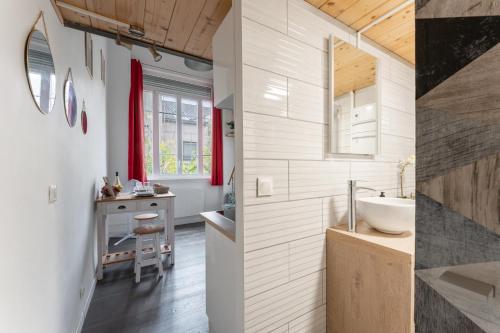 - deux images d'une salle de bains avec lavabo et comptoir dans l'établissement Silk - Studio en plein coeur de Lyon, à Lyon