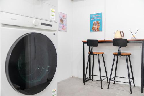 a kitchen with two bar stools and a microwave at Mutal Stay in Seoul