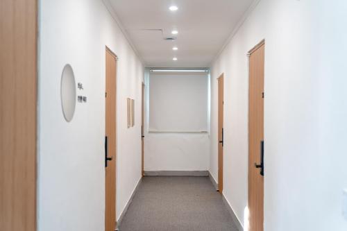 a corridor of an office with white walls and doors at Mutal Stay in Seoul