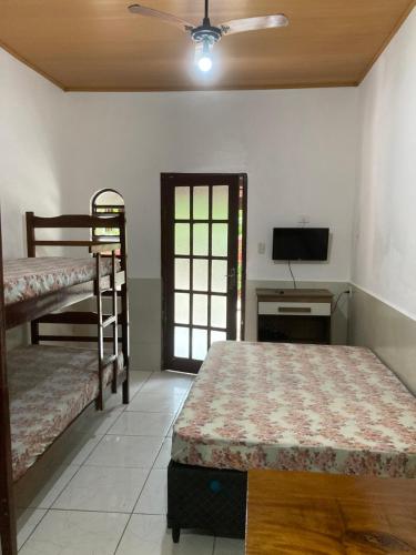 1 Schlafzimmer mit 2 Etagenbetten und einem Flachbild-TV in der Unterkunft Casa Temporada Damata in Ubatuba