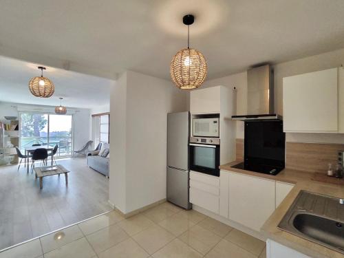 Il comprend une cuisine et un salon avec deux lampes suspendues. dans l'établissement L'Escale Méditerranéenne, Ensoleillé et Vue Mer, à La Seyne-sur-Mer