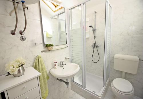 a bathroom with a shower and a sink and a toilet at House Ivi in Supetar