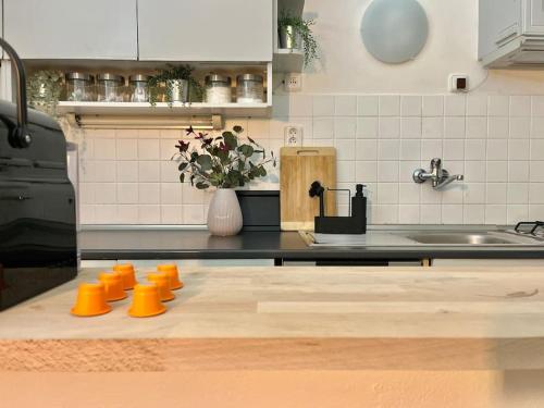 a kitchen with a counter with orange cups on it at Beautiful New Town Apartment in Prague