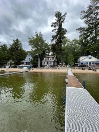 a dock in the water with houses in the background at CAMP LINDY LIMIT 7 cottage in North Sebago
