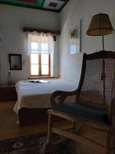 a bedroom with a bed and a chair and a window at Armoloi Traditional - Guest House in Konitsa