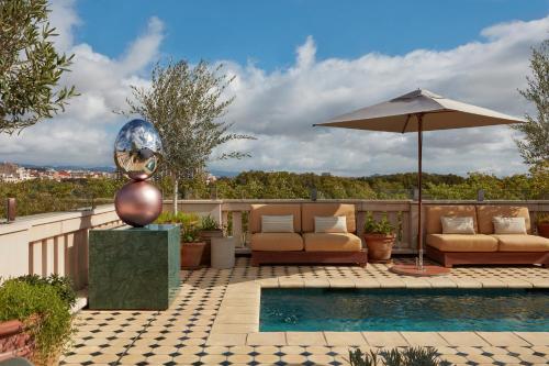 a pool with two chairs and an umbrella at Miiro Borneta in Barcelona