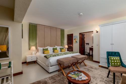 a bedroom with a bed and a table and chairs at The Emin Pasha Hotel & Spa Kampala in Kampala