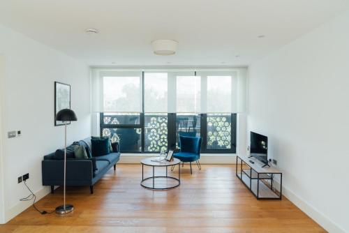 a living room with a couch and chairs and a television at Access Brick Lane in London