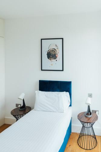 a bedroom with a bed and two tables at Access Brick Lane in London