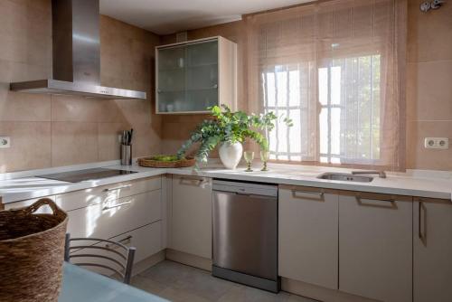 eine Küche mit weißen Schränken und einer Spüle und einem Fenster in der Unterkunft Casa Cortijo del Aire, Granada in Albolote