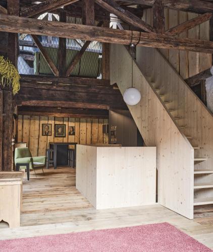 a large room with wooden ceilings and a staircase at Cedä-M in Dosoledo