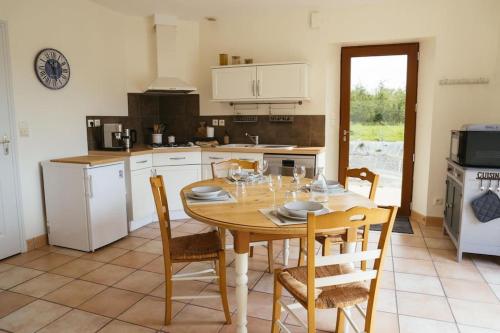 - une cuisine avec une table et des chaises en bois dans l'établissement La Maison des Vergers, à La Souris