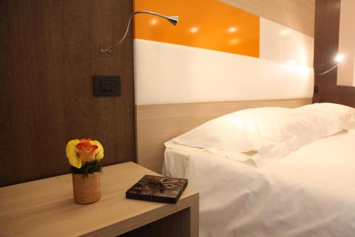 a room with a bed and a table with a vase of flowers at Hotel Metrò in Milan