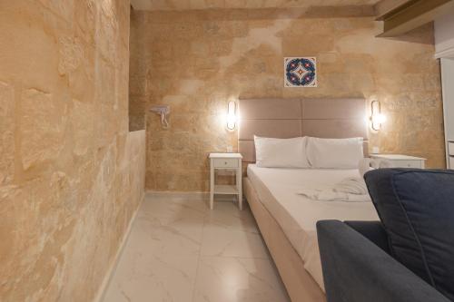une chambre avec un lit et un canapé dans une pièce dans l'établissement Palazzo Stella Ground Floor Studio by Vallettastay, à La Valette