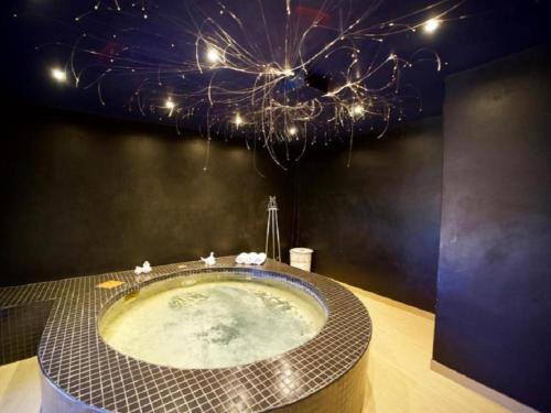 a bathroom with a large tub with a chandelier at Shelanti Game Reserve in Marken