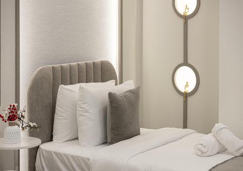 a bedroom with a bed with white pillows and a mirror at Dubai Marina Luxury 4 BHK # Sea, Ain Dubai & Palm View # in Dubai