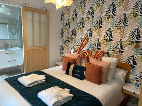 une chambre avec un lit avec deux oreillers dessus dans l'établissement Côté Jardin, à Bobital