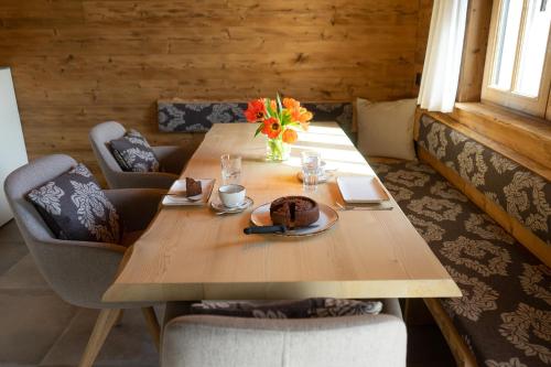 a wooden table with a plate of food and flowers on it at Chalet Brisi in Wildhaus