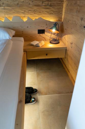 a bedroom with a bed and a desk with a lamp at Chalet Brisi in Wildhaus