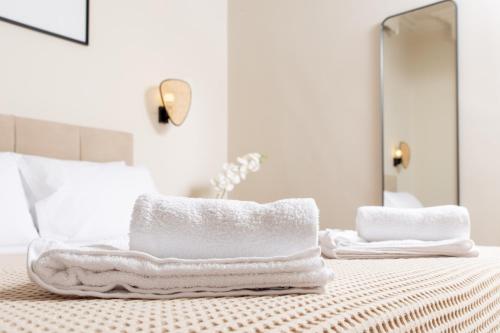 1 cama con toallas y espejo en DayDin Apartments - Din Kastoria, en Kastoria