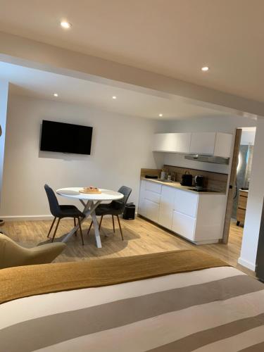 a living room with a table and a kitchen at Studio équipé avec Parking Le Chasseland in Chassieu