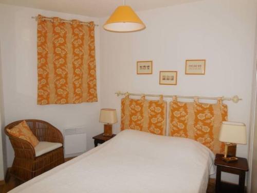 une chambre avec un lit blanc et une chaise dans l'établissement Paradiski proche des pistes plan peisey, à Peisey-Nancroix