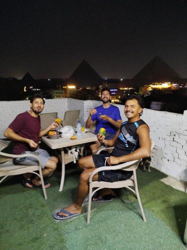 a group of men sitting at a table at night at Eyad Pyramids view in Cairo