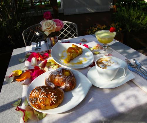 a table with plates of pastries and a cup of coffee at Hotel Metrò in Milan