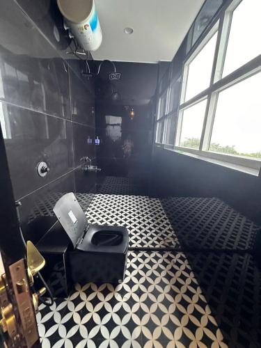 a bathroom with a toilet and a black and white floor at Prana Healing House in Pune