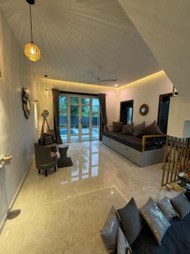 a large living room with a bed and a couch at Prana Healing House in Pune