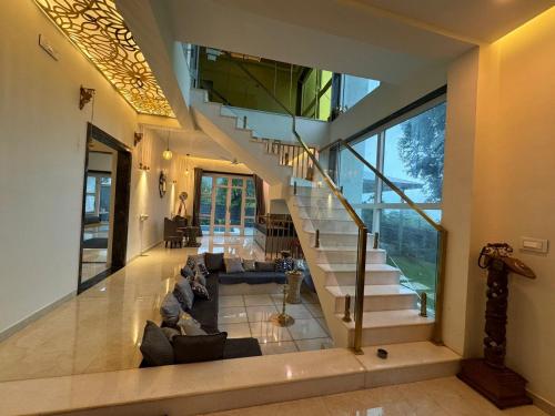 a living room with a couch and a staircase at Prana Healing House in Pune