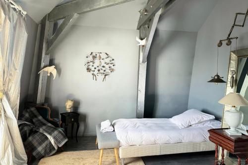 a bedroom with blue walls and a bed and a table at Maison d'hôtes Stella Cadente in Provins