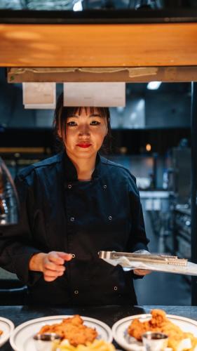 a woman in a kitchen holding a plate of food at Clarion Hotel Stockholm in Stockholm