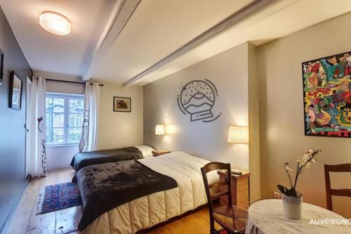 ein Schlafzimmer mit einem Bett und einem Tisch in der Unterkunft Gîte des Remparts in Besse-et-Saint-Anastaise