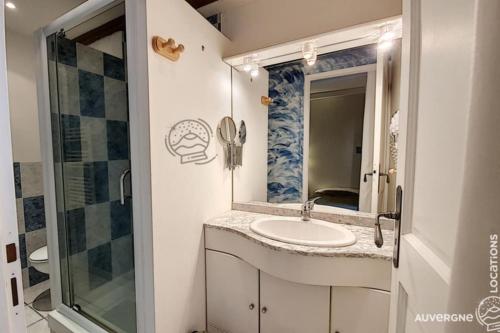 ein Badezimmer mit Waschbecken und Spiegel in der Unterkunft Gîte des Remparts in Besse-et-Saint-Anastaise