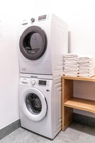 a washing machine and a dryer next to a wall at H11 Aparthotel in Kraków