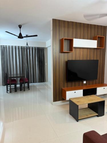 a living room with a television and a table at Aami dhivahi guest house in Trivandrum