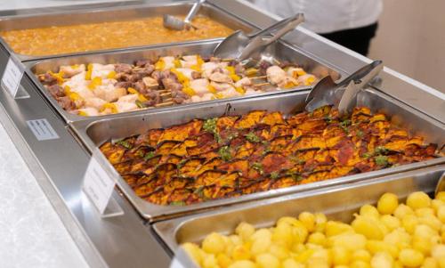 a buffet with many different types of food in trays at Forte Family Village - Azzurro Club in Sella Nevea