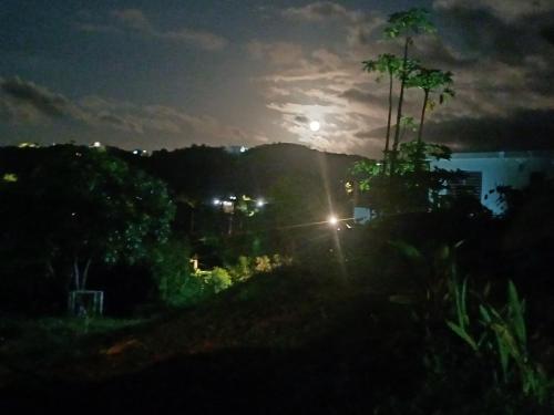 a night view of a city with the moon in the sky at Rooster Run Guest House offers Vieques travelers newly furnished quaint affordable airconditioned rooms and only steps from the Ferry and nearby beaches in Vieques