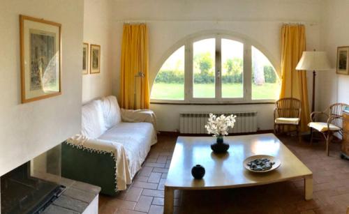 a living room with a couch and a table at La Casa Rossa in Marina di Bibbona