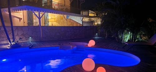 a swimming pool at night with lights next to a building at La Villa Baie du Marin in Le Marin